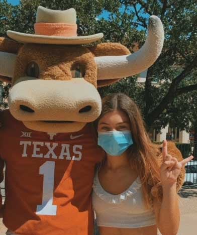 IEFS recipient Cagla Hoskara signing Hook 'em! in masks with Bevo