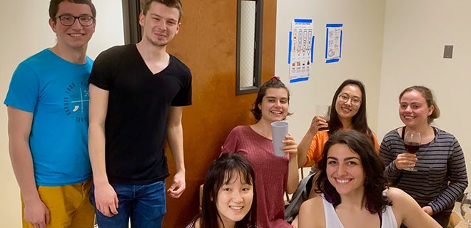 hannah stands with friends in a dorm hallway