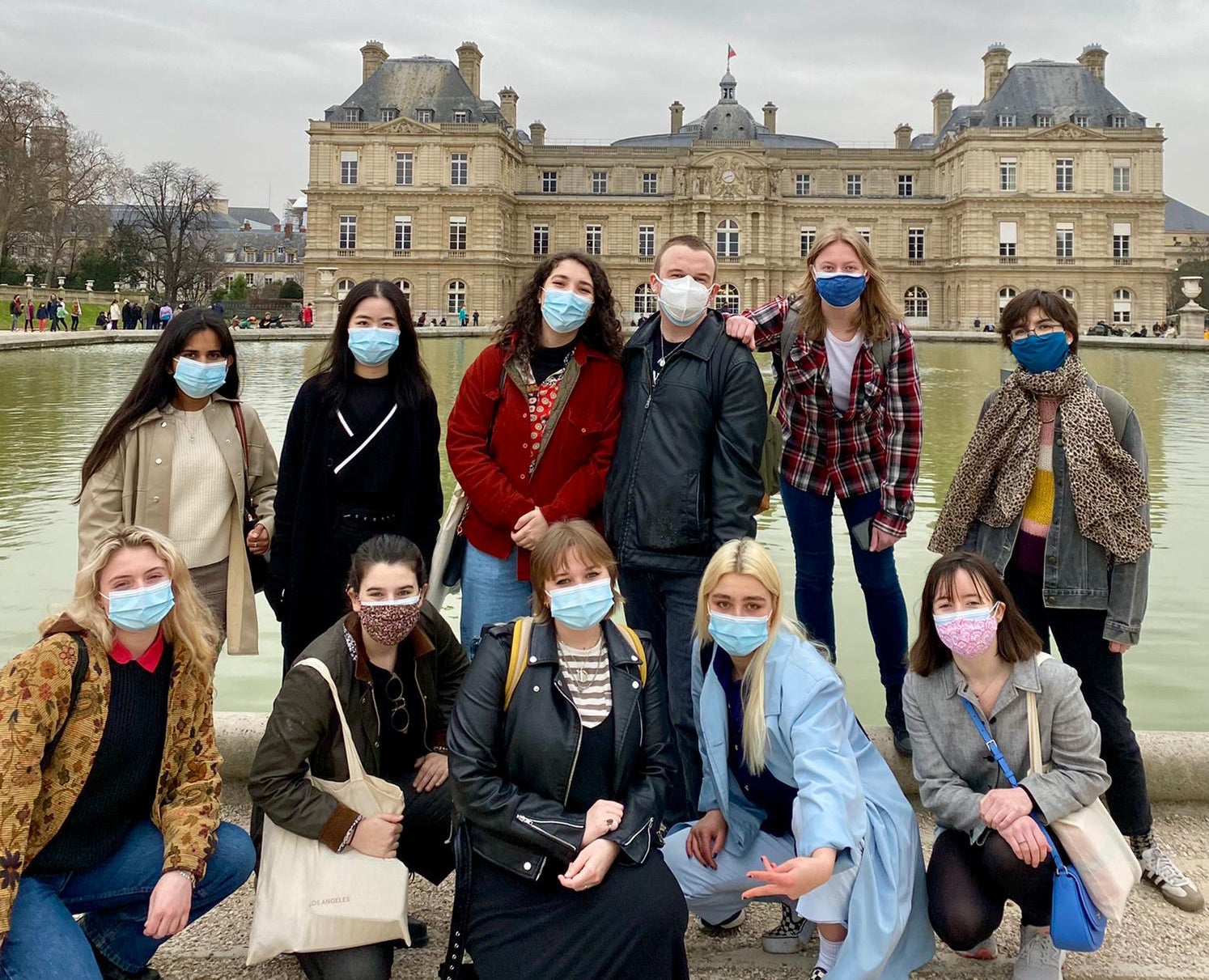 sophie and a group of friends stand in front of a building in france