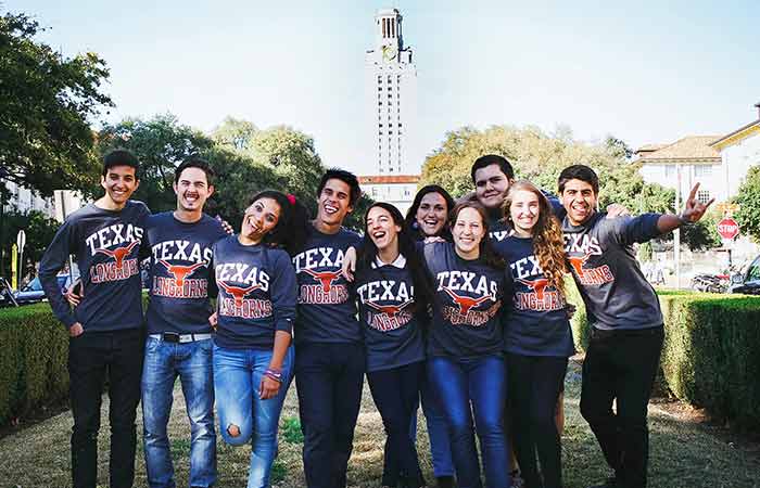 UT students wearing longhorn shirts posing for camera.