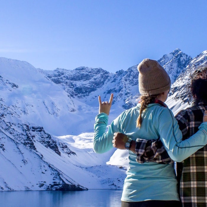 Longhorns show their UT pride while looking over a lake at huge snow-covered mountains on a blue sky day