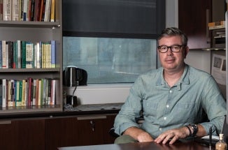 jason cons sits at his desk
