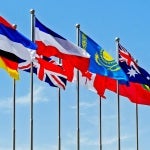 Row of flags from around the world against blue sky
