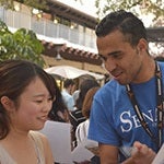 Staff with lanyard assisting asian woman
