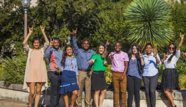 a group of students hold up hook em hand signs