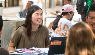students talk and study at a table