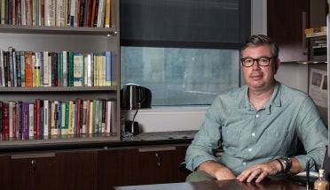 jason cons sits at his desk