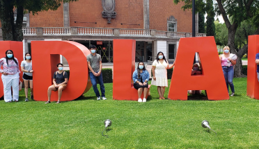 students stand in front of giant red letters reading "UDLAP"