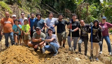 SABIC Foundation Year students smile while posing in front of a volunteer site in Puerto Rico