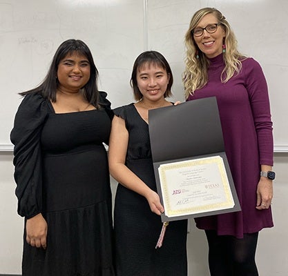 English language students display course certificate with their teacher