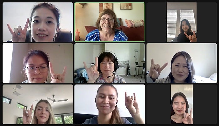 ELC students and teacher throw the "Hook 'em Horns" sign in a Zoom class